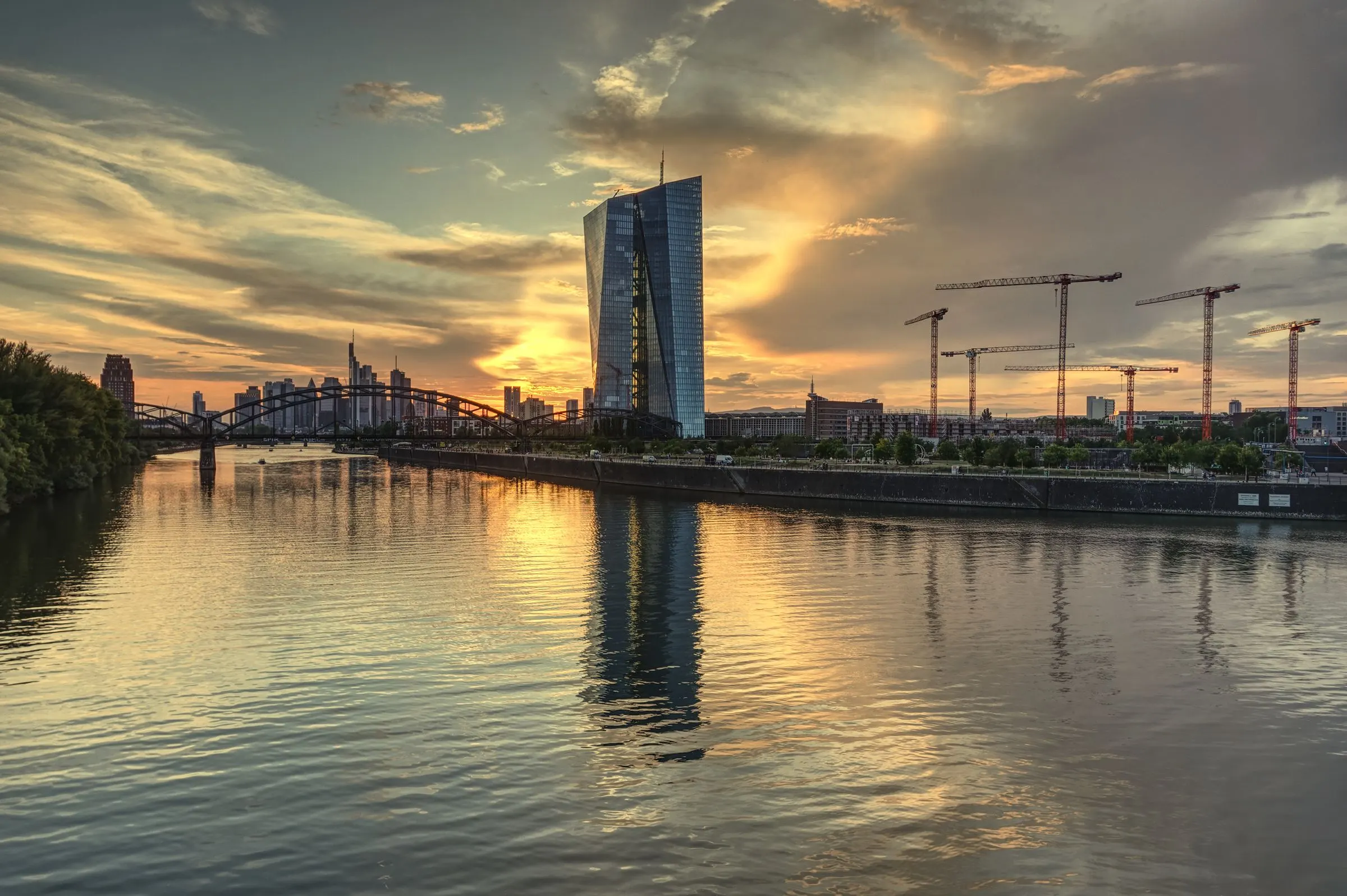 Frankfurter Skyline mit EZB-Gebäude bei Sonnenuntergang, gespiegelt im Main